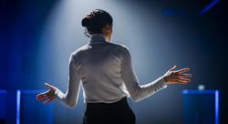 Woman speaking on stage facing audience