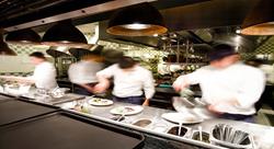 multiple cooks working on the line plating dishes in a nice restaurant