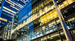 side of office building at night with office lights on