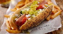 chicago style hot dog in a poppyseed bun surrounded with french fries