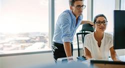 Corporate professionals looking at computer monitor in office