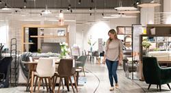 smiling female shopper at a furniture store looking at a table and chairs