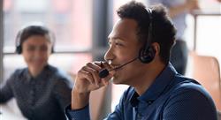 Smiling young call center agent laughing at workplace